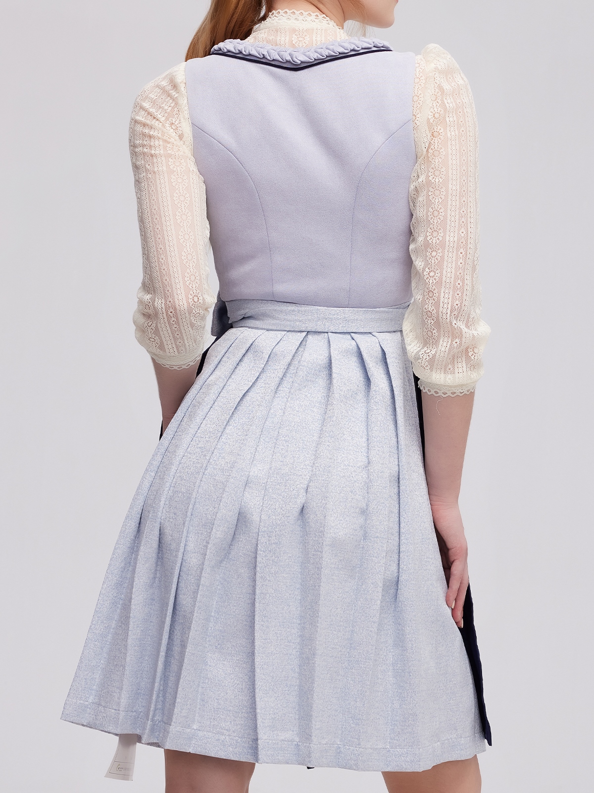 Modernes blaues Dirndl mit weißer Bluse in urbanem Setting