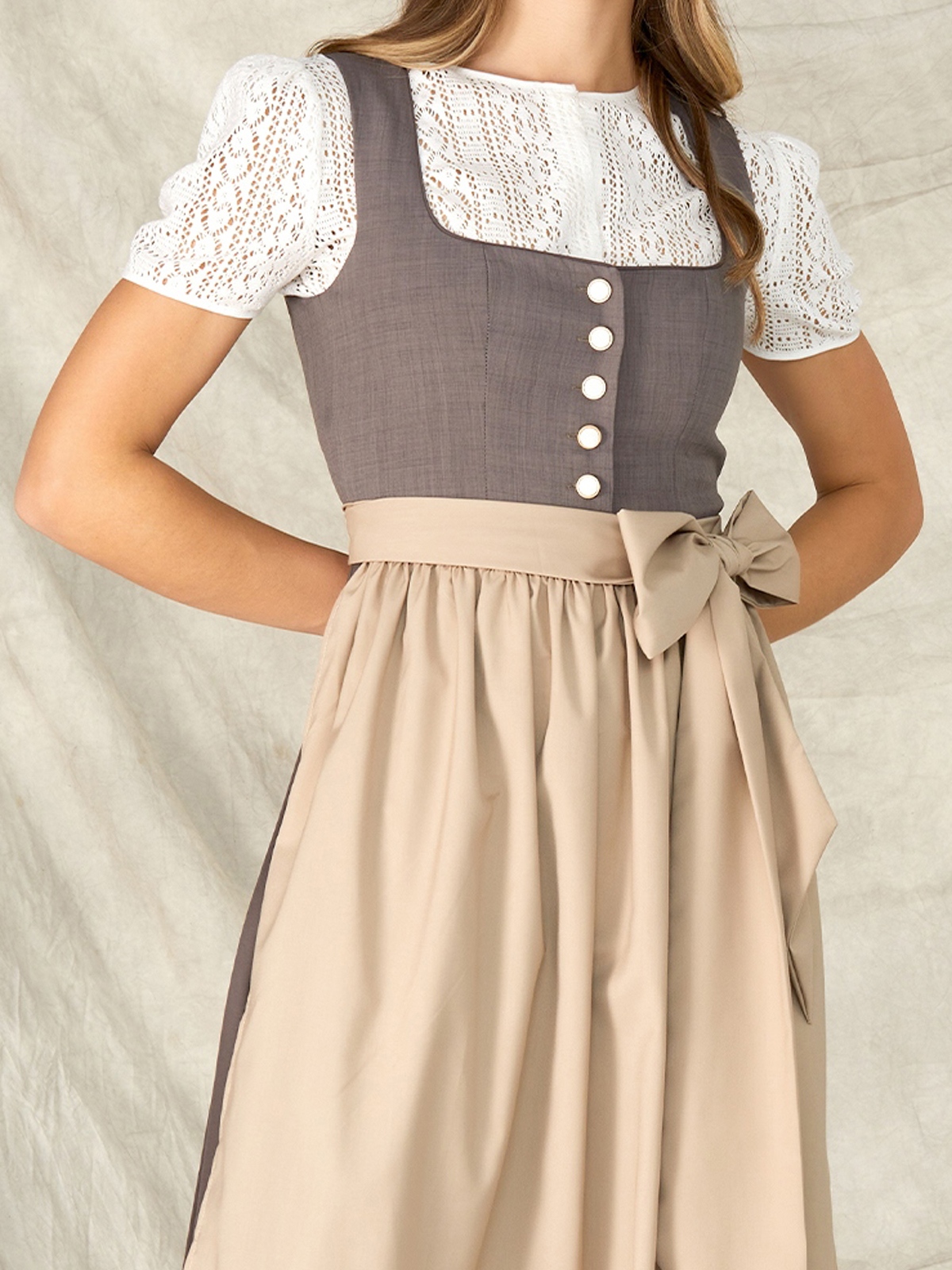 Ein graues Dirndl mit modernem Schnitt, das die Vielseitigkeit traditioneller Tracht zeigt